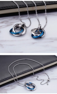 Close-up of interlocking stainless steel triple ring pendants with inset rhinestones