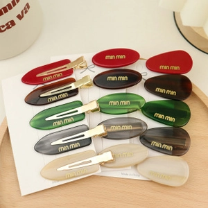 Flat lay of 10-piece colorful bow hair clip set on a decorative wooden tray