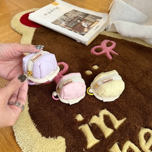 Quilted round headphone case with pearl and smiley charms on soft textured fabric