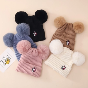Winter knit hat for girls featuring dual pom-poms and cute unicorn embroidery