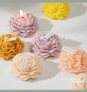 Primo piano dettagliato di candele profumate a forma di peonia con petali di cera colorati