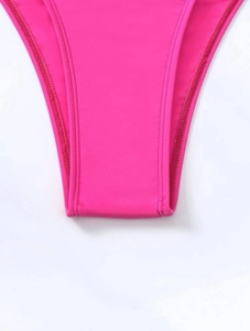 Close-up of rose pink high-stretch swimwear fabric with fine flatlock stitching details