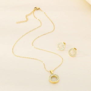 Dettaglio del set collana dorata e orecchini a lobo tondi con cristalli pavé lucidi