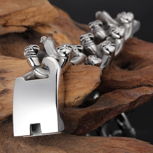 Macro shot of silver stainless steel skull bracelet on dark driftwood background
