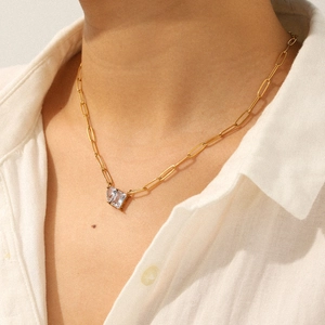 Detailed close-up of 18k gold-plated necklace with a radiant square zircon on model