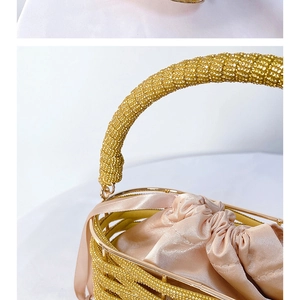Macro detail of gold bucket bag featuring dense rhinestone inlay and satin drawstring liner