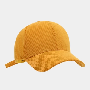 Detail of mustard yellow corduroy baseball cap showing texture and side adjustment strap