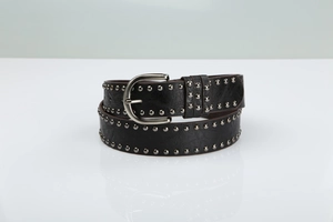 Close-up of black leather punk belt with silver metal studs and classic horseshoe buckle