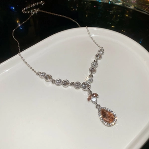 Detail einer eleganten Silberhalskette mit champagnerfarbenem Kristall auf Porzellan