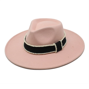 Detail of pink wool fedora hat featuring black ribbed ribbon with white bead embellishment