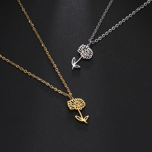 Detailed view of hollow flower pendants in gold and silver finish on black surface
