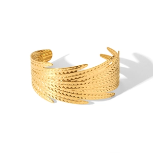 Vue détaillée de la texture plume dorée sur ce bracelet jonc en acier inoxydable poli