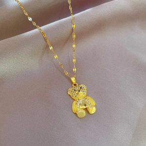 Gros plan détaillé d'un collier pendentif ours doré serti de cristaux sur de la soie