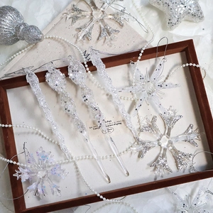 Sparkling silver snowflake and icicle ornaments in a decorative display tray