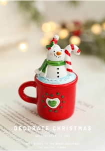 Macro detail of snowman resin figurine inside red Christmas cup with heart relief