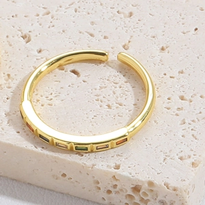 Detail of adjustable gold ring featuring a row of vibrant colorful square gemstones