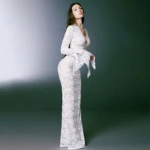 Detail of elegant white lace dress featuring intricate floral patterns and sheer texture