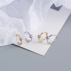 Detail showing S925 silver beaded huggie hoops with inset purple gemstones in gold and silver