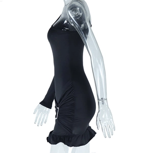 Close-up of the elegant ruffled hem and metallic ring details on the slim black dress