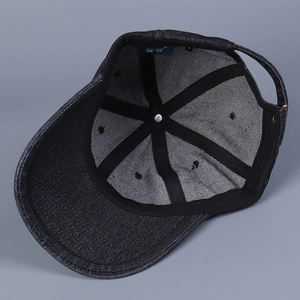Detailed interior of a black washed denim baseball cap with metal buckle and inner sweatband