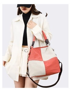Detail of canvas tote bag showing contrast color stitching and premium leather strap attachment