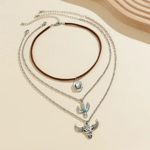 Detail of bohemian layered necklace with turquoise cactus and vintage bull head charms