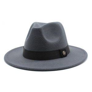 Detail of dark grey fedora hat with black ribbon band and golden M metal logo