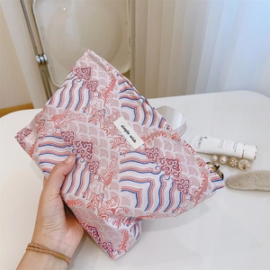 Detail of traditional wave pattern cosmetics bag held by hand with simple wish label