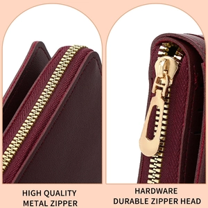 Detail of premium gold metal zipper and durable puller on a burgundy leather wallet