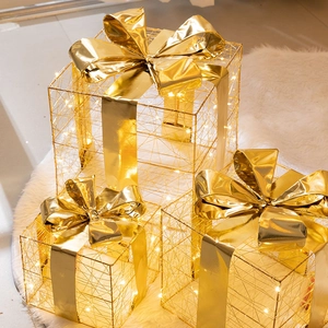 Three-piece set of golden hollow lighted Christmas gift boxes with festive LED warm glow