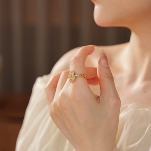 Détail de la bague fleur de lys plaquée or avec anneau texturé et cristaux scintillants