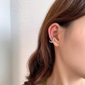 Close-up of minimalist silver double-layer ear cuff worn on woman's ear cartilage