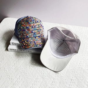 Detail of colorful beads and rhinestones on light blue and grey stylish baseball cap