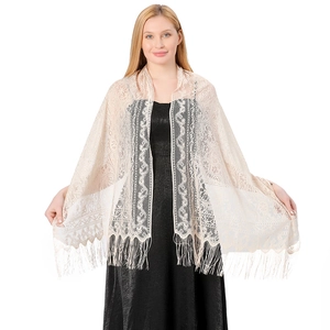 Detail of beige lace shawl with floral embroidery and long fringes on black dress
