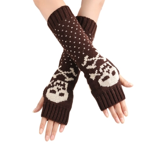 Detailed knit texture of dark brown fingerless gloves with white skull and dot patterns