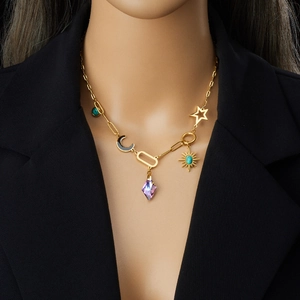 Collana con catena a graffetta dorata con ciondoli sole e luna turchese su blazer