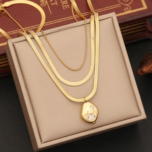 Detail of layered gold necklace with irregular pendant and sparkling crystal accent