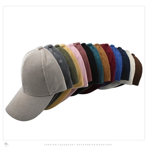Detailed stack of corduroy baseball caps showing multiple colors and striped texture
