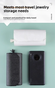 Portable jewelry roll organizer in white and black leather compared to a smartphone