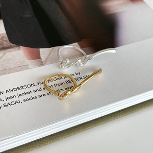 Artistic 925 sterling silver fluid sculpture rings in gold and silver on a magazine