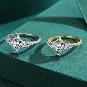 Elegant silver and gold marquise cut zircon rings with pear side stones on green background