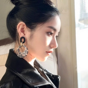Vintage leopard print geometric round hoop earrings worn by a model in natural side lighting