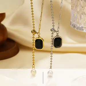 Macro detail of titanium steel chain with black rectangle pendant and white pearl