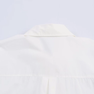 Detail of white poplin shirt collar and shoulder stitching with premium button accents