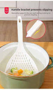 Detail of white slotted spoon handle with anti-slip support rest on a cooking pot