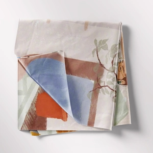 Close-up of folded bohemian tapestry with colorful floral patterns on soft fabric