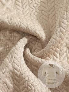 Close-up of beige knit jacquard fabric showing geometric texture on men's polo shirt