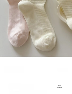 Détail de chaussettes en coton peigné rose et blanc cassé avec texture en maille côtelée