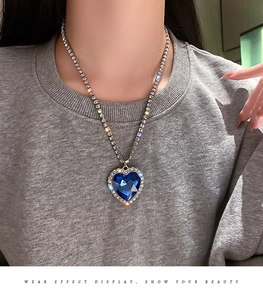 Nahaufnahme eines großen blauen Herzkristall-Anhängers mit Strass auf einer Tenniskette
