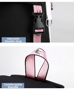 Detail view of adjustable shoulder strap and reinforced top handle on a black backpack